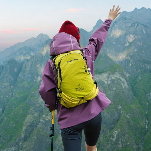 Woman in mountains wearing a yellow day pack while hiking 